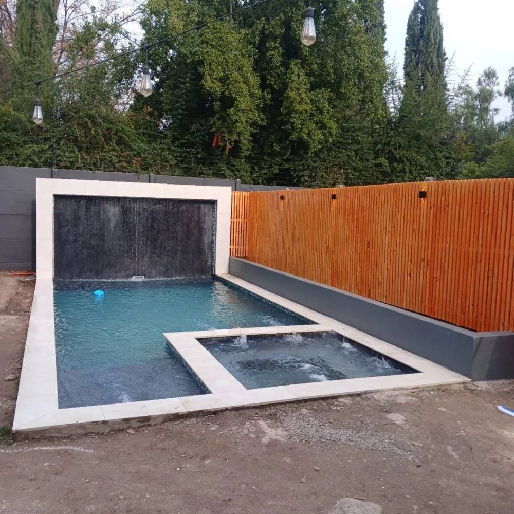 Piscina con cascada y muro de madera